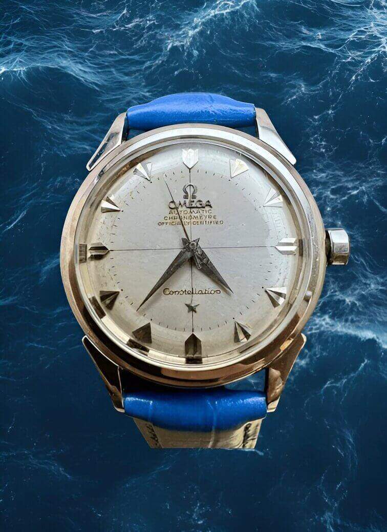 นาฬิกาตัวเรือนเงินที่หรูหรา หน้าปัดสีขาวสะอาดตา เข็มชี้สีดำตัดกับสายหนังสีน้ำเงินให้ความรู้สึกสง่างามและคลาสสิก