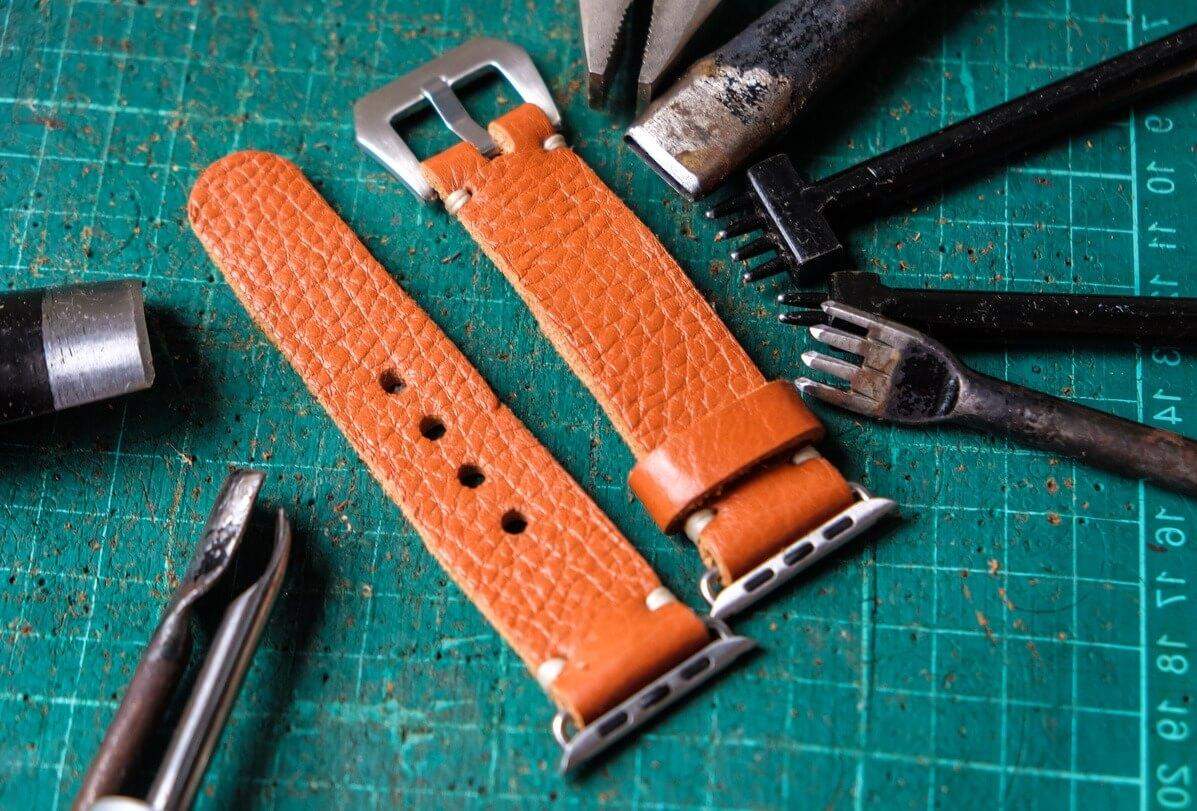 เครื่องมือสำหรับการเปลี่ยนสายและสายหนังสีดำข้างๆ สำหรับการเปลี่ยนสายนาฬิกา