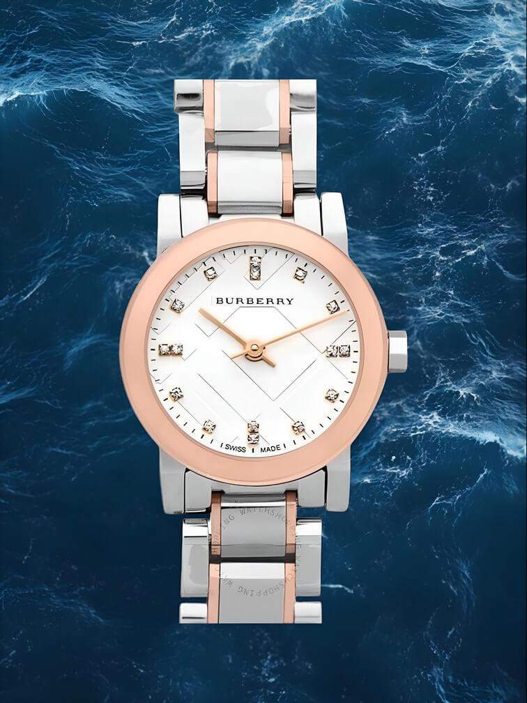 นาฬิกาสีเงินพร้อมขอบเบซิลทอง หน้าปัดสีขาวและอัญมณีเหมือนหินบนหน้าปัด ดีไซน์หรูหราและมีความสง่างาม