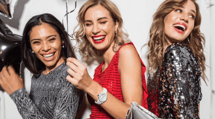 ผู้หญิงกลุ่มหนึ่งกำลังเฉลิมฉลอง โดยมีผู้หนึ่งสวมใส่นาฬิกา Guess รุ่นใหม่ล่าสุด เสริมลุคให้ดูหรูหราในช่วงเวลาพิเศษ