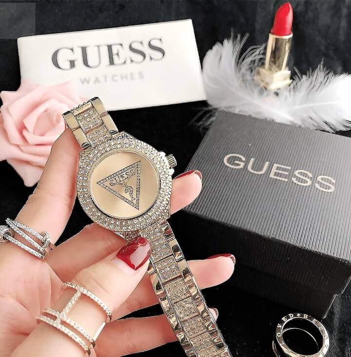ผู้หญิงกำลังรับนาฬิกา Guess รุ่นใหม่ล่าสุดเป็นของขวัญ สวมใส่ความประทับใจจากของขวัญที่หรูหราและมีสไตล์