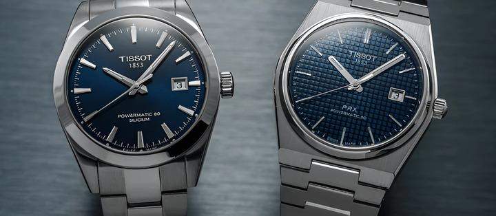 นาฬิกาคลาสสิก 2 เรือนที่มีตัวเรือนสแตนเลสสตีลสีเงินและหน้าปัดสีน้ำเงินเข้ม