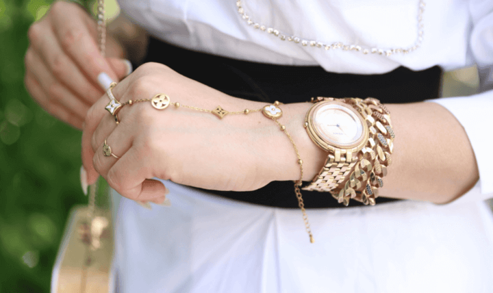 ผู้หญิงสวมเครื่องประดับทองและนาฬิกาทองคำที่เข้ากับลุคหรูหรา