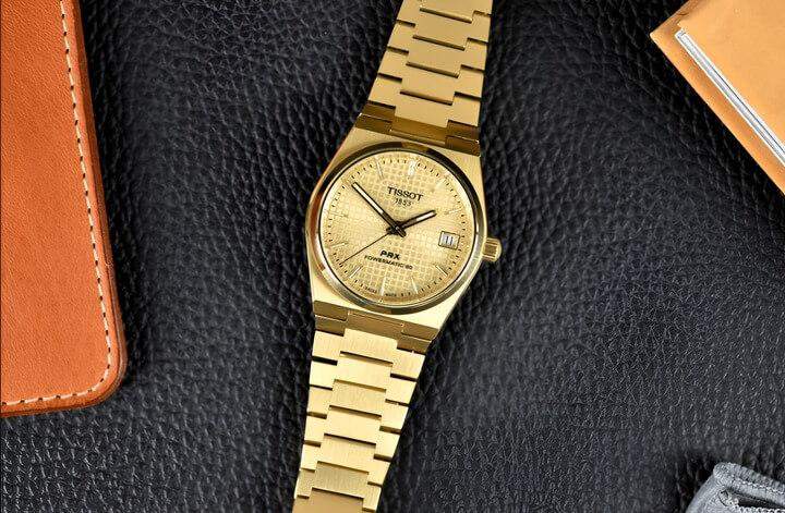 PRX รุ่นสีทองทั้งหมด แสดงถึงความหรูหราและความประณีตของคอลเลคชั่น พร้อมพื้นผิวสีทองเงางาม หน้าปัดสีทอง และเข็มจับเวลาที่เข้ากันอย่างมีเสน่ห์