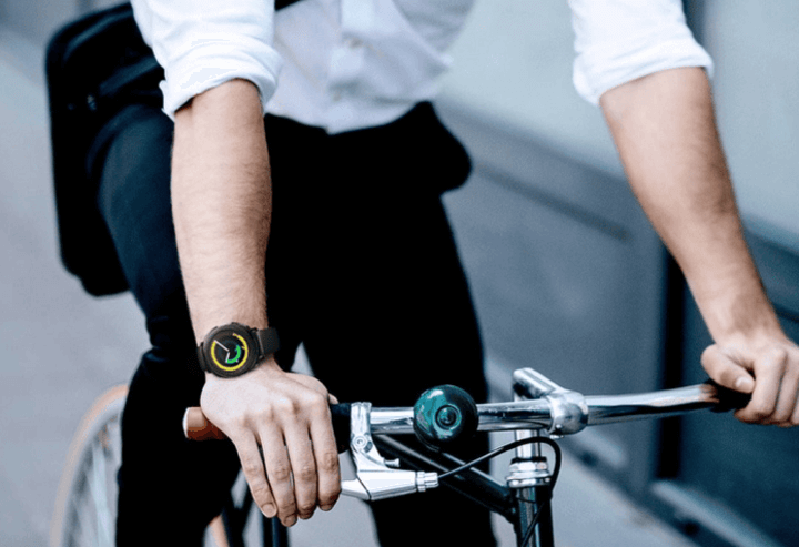 ชายคนหนึ่งขี่จักรยาน สวมใส่นาฬิกากีฬาที่ทนทานและเหมาะกับกิจกรรมกลางแจ้ง