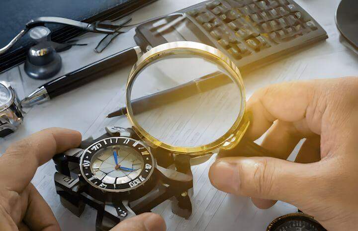 ผู้ชื่นชอบนาฬิกาตรวจสอบนาฬิกาอย่างระมัดระวังด้วยแว่นขยายเพื่อพิจารณารายละเอียดและงานฝีมือที่ซับซ้อน