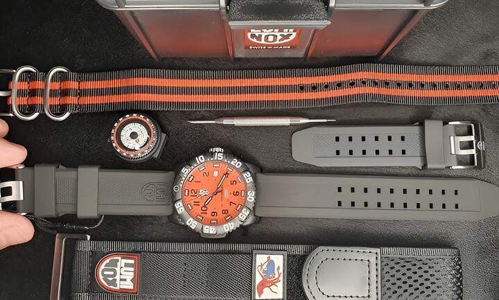 นาฬิกาแข็งแรงสีดำทั้งหมด พร้อมหน้าปัดสีส้ม และชุดสายที่สามารถเปลี่ยนได้ เหมาะสำหรับการผจญภัยและกิจกรรมกลางแจ้ง