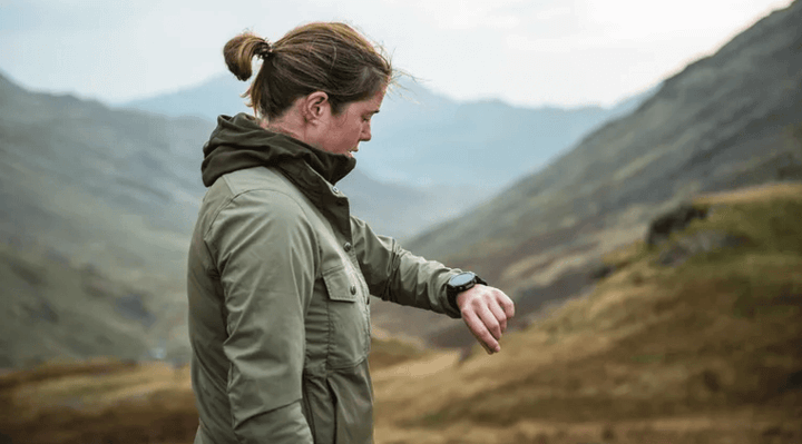 ผู้หญิงสวม T-Rex 3 อยู่กลางแจ้งบนภูเขาในวันที่มีเมฆมาก แสดงให้เห็นการใช้งานสมาร์ตวอทช์ทนทานในสภาพแวดล้อมธรรมชาติ
